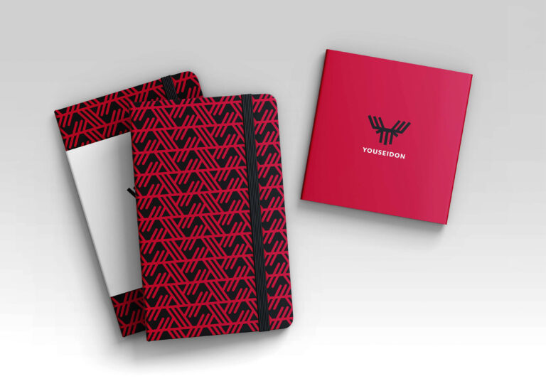 Preview of the Youseidon logo on a red notebook.